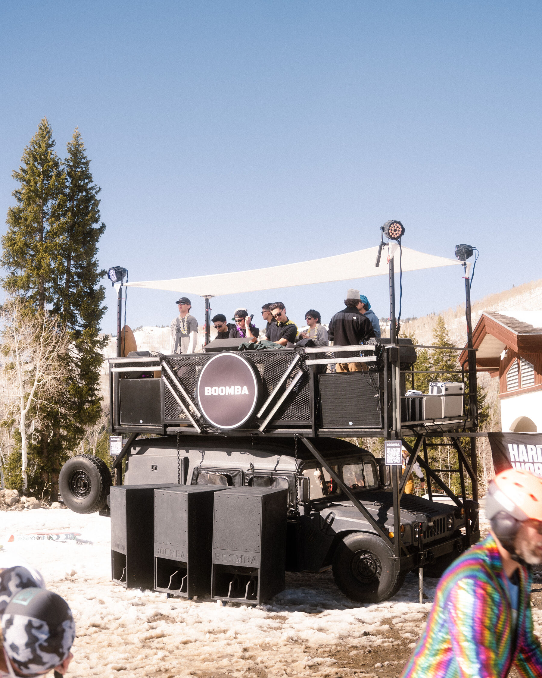 The BOOMBA soundcar parked on a snowy ski run with a crowd on deck